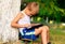 Boy Child playing with Tablet PC Outdoor