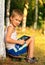 Boy Child playing with Tablet PC sitting on skateboard Outdoor