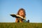 Boy child reading book, lying down on green grass. Kids adventure, freedom and carefree children.