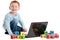 Boy child at school with computer and kids blocks