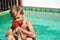 Boy child shoots with a water pistol. Water active games at the pool