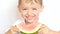 Boy child sitting at table with pleasure eating watermelon on white background, close-up.