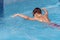 Boy child swimmer swim in swimming pool with butterfly style. Water sports, training, competition, summer activity