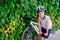 Boy child in white bicycle helmet inflating tire