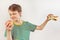 Boy chooses between sandwich and fruit on white background