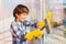 Boy cleaning windows with sponge and glass wiper