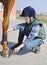 Boy cleans a hoof of horse