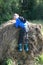 Boy climbing onto stack of straw