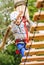 Boy climbing rope-ladder in adrenalin park