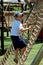 Boy climbing a rope ladder in playground