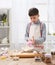 Boy cooking in home kitchen, making dough, healthy and homemade food concept