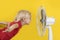 Boy cools off with ventilator. Portrait on yellow background. Summer heat