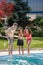 Boy covering face with hands and parents near pool