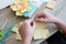 Boy creating paper flower for mom. Mother day, DIY on quarantine or online education concept. Soft focus