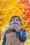 Boy with crocheted beard against Autumn foliage background