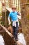 Boy Crossing Stream Balancing On Log At Activity Centre