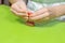 Boy decorates a cinnamon cookie. He holds a tube of red icing in his hands and squeezes it on the cake.