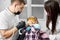 Boy in dental chair closes mouth with hands, fearing dentist