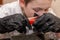 Boy dips an egg in a glass with paint. Boy paints easter eggs