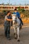 Boy with a disability having an assisted equine therapy session with a physiotherapist.