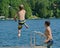 Boy dive bombing off dock into lake