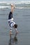 Boy does handstand in wet sand.