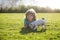 Boy with dog puppy. Blond happy kid with her chihuahua doggy portrait lying on lawn.