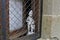 Boy and dog statue looking through window guard in Rupit