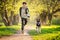 A boy with a dog walk in the park on a sunny spring evening, run along the road. Friendship of man and animal, healthy lifestyle
