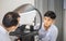 Boy doing eye test checking examination with autorefractor in optical shop, Optometrist doing sight testing for child patient, Eye