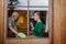 Boy with Down syndrome with his grandmother cleaning window at home.