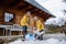 Boy with Down syndrome with his mother clearing snow from path with shovel in front of house.