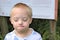 Boy with down syndrome poses for a portrait outdoors.