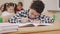 Boy drawing in copybook in classroom.