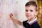 Boy draws on the wall with colored chalk. The child is engaged in creativity at home