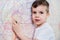 Boy draws on the wall with colored chalk. The child is engaged in creativity at home