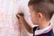 Boy draws on the wall with colored chalk. The child is engaged in creativity at home