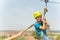 A boy dressed in a protective helmet and insurance, goes down the rope, descends holding a protective cable