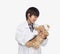 Boy dressed up as doctor checking teddy bear\'s vital signs, studio shot