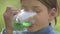 Boy drinking sugar water. The child drinks fruit green drink.