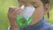 Boy drinking sugar water. The child drinks fruit green drink.