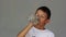 Boy drinks water from a bottle on a gray background