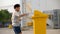 Boy drop empty bottle in yellow bin