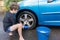 Boy earning pocket money cleaning blue compact car