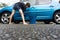 Boy earning pocket money cleaning blue compact car