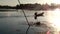 Boy earns living as fisherman in a lake using boat. silhouettes