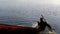 Boy earns living as fisherman in a lake using boat. silhouettes