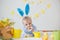 Boy with Easter bunny ears and colorful eggs and flowers