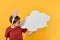 A boy with Easter ears holds in his hand a blank poster in the form of a cloud and looks at it. Advertising, text, advertisement,