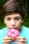 Boy eat doughnut with pink strawberry